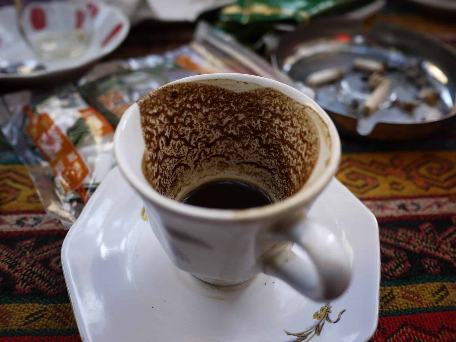 Hands carefully seating a paper filter into a glass coffee dripper.