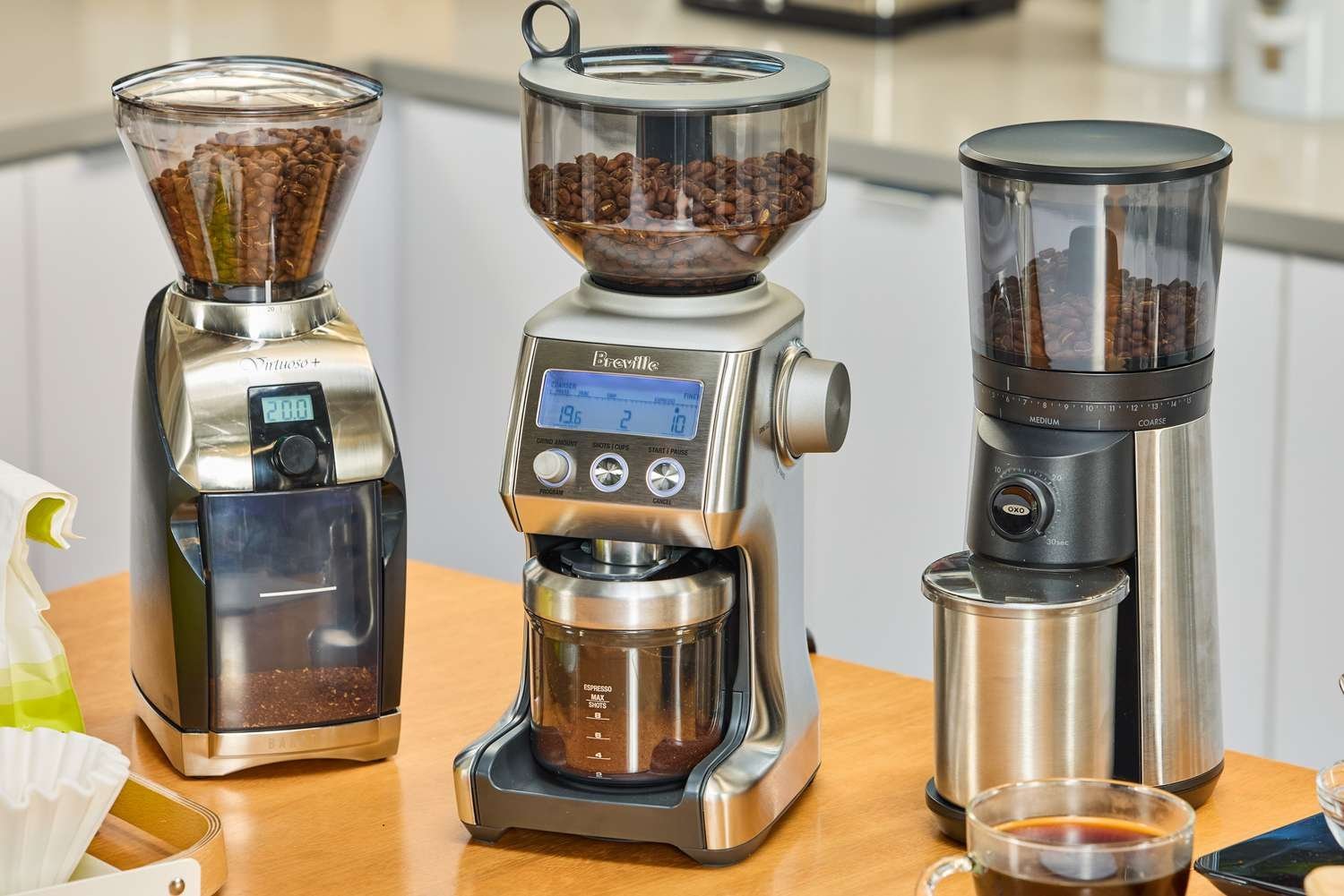 A coffee grinder and coffee beans on a kitchen counter for brewing coffee.