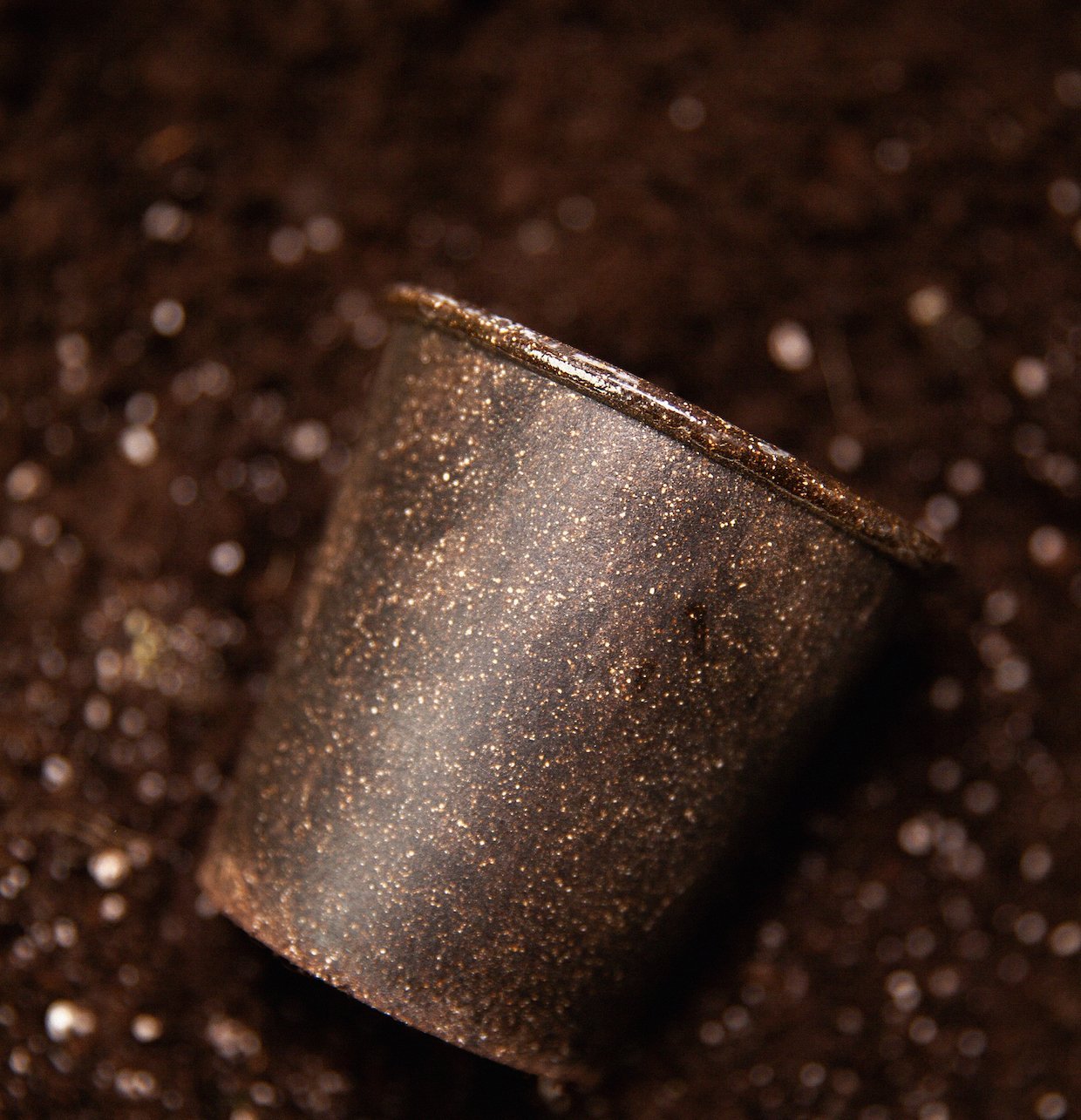 A person holding a coffee portafilter while studying coffee brewing techniques.