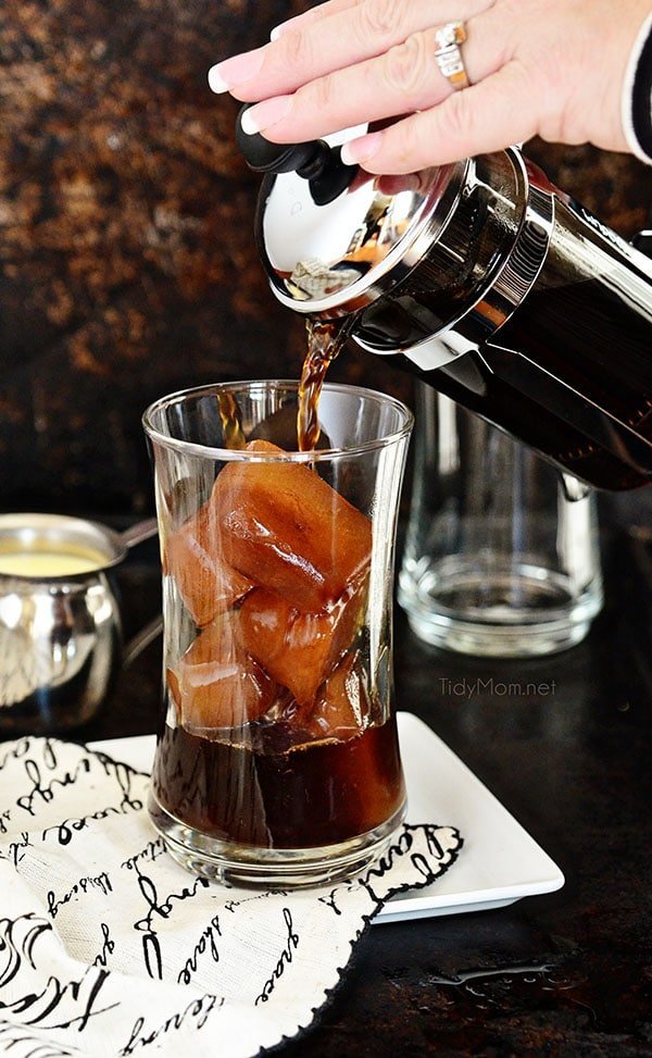 Various coffee brewing tools arranged on a wooden surface for a cold brew guide.