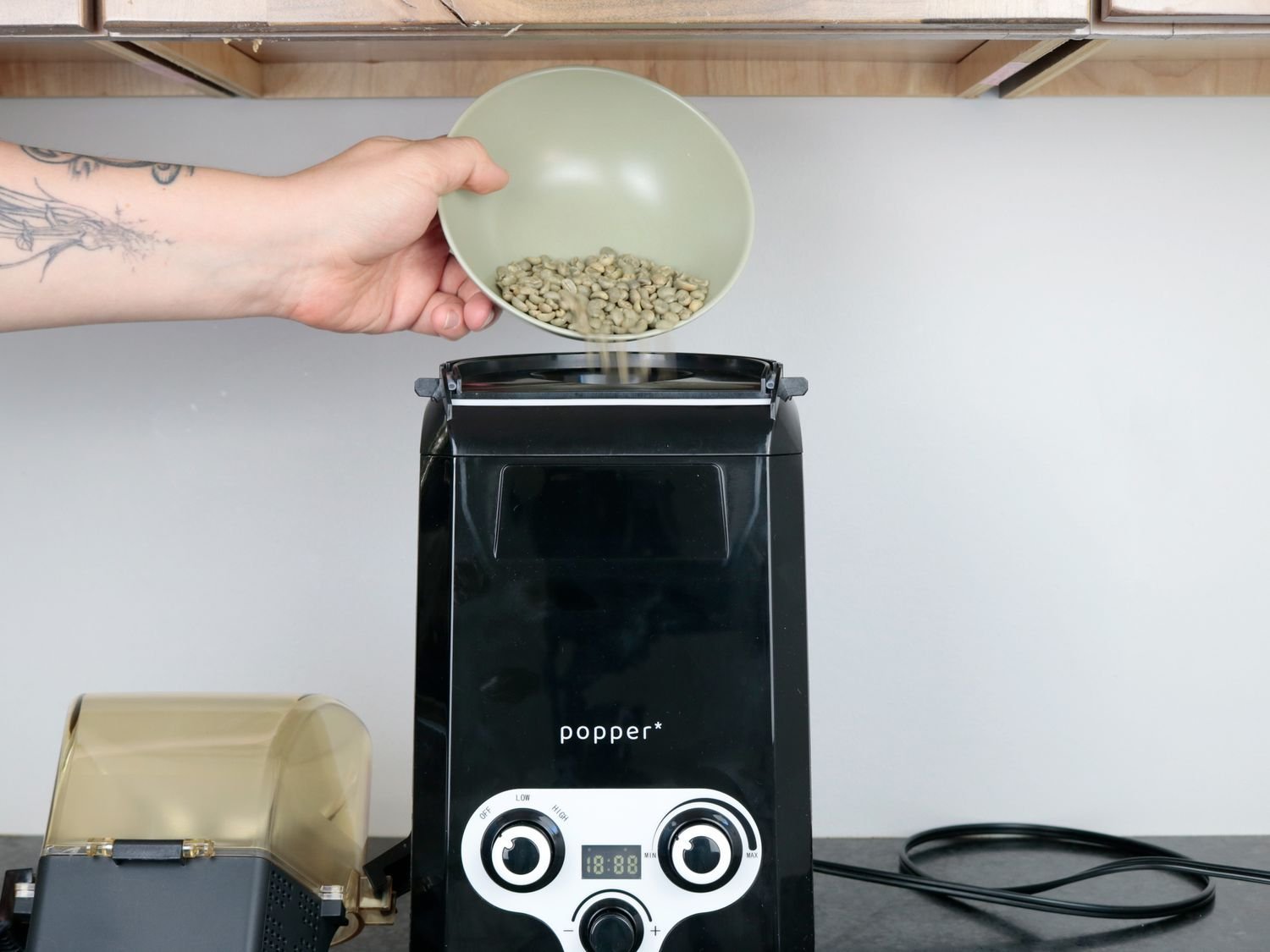 Carefully inspecting roasted coffee beans to ensure consistent roast quality and appearance.