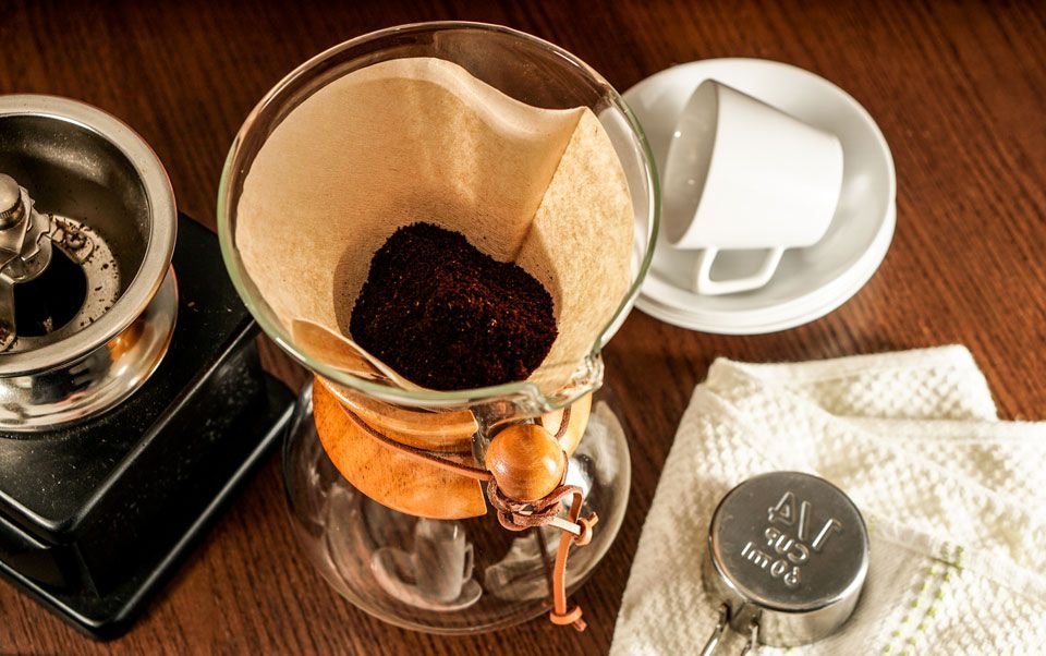 Hot water pouring over coffee grounds to start the brewing process.
