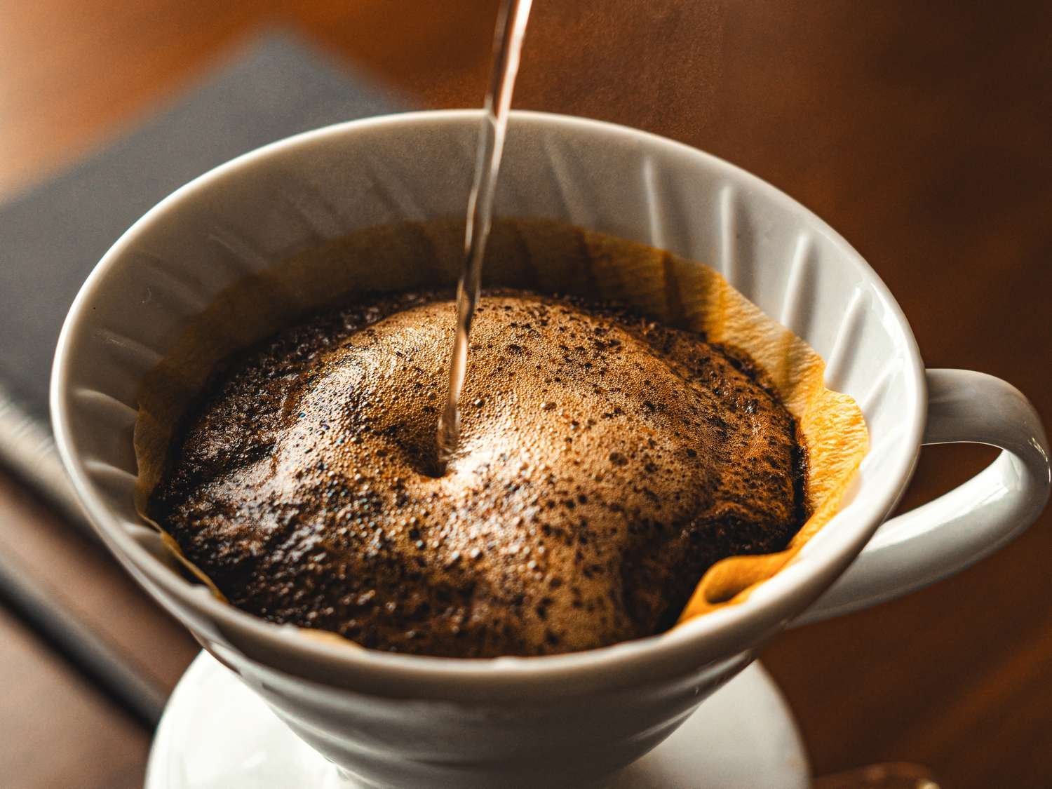 A fresh cup of coffee waiting on a wooden table in the morning.