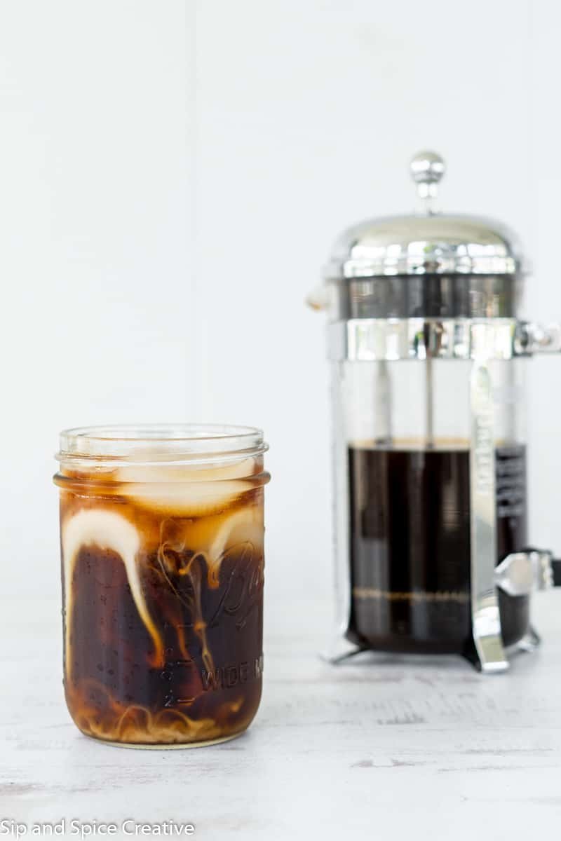A glass carafe of cold brew coffee resting in a clean, minimalist kitchen setting.