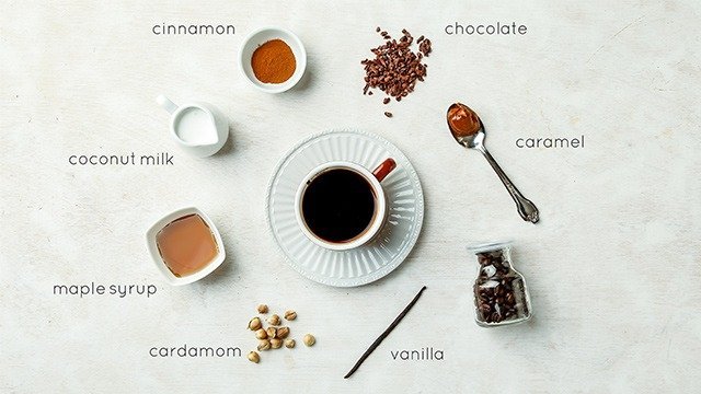A steaming cup of coffee next to a notebook in a bright kitchen.
