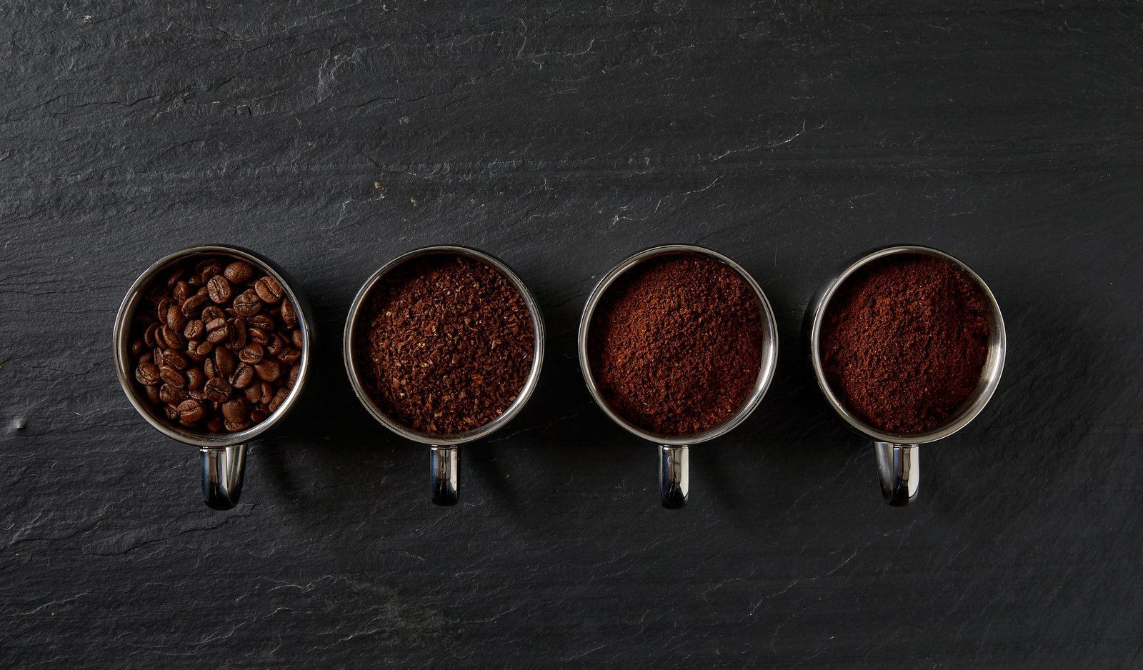 Freshly ground coffee beans prepared for brewing in a glass press.