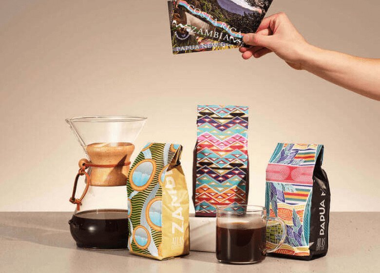 A bag of coffee beans displayed alongside a map representing the Atlas Coffee Club global tour.