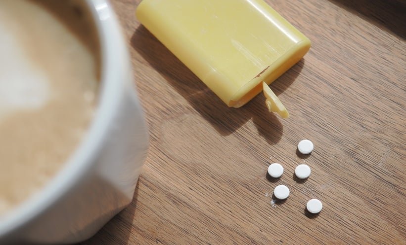 High quality whole coffee beans contrasted against instant coffee on a kitchen counter.