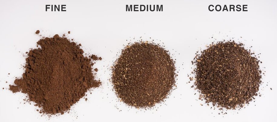 A pile of fine ground coffee sitting next to a portafilter on a table.