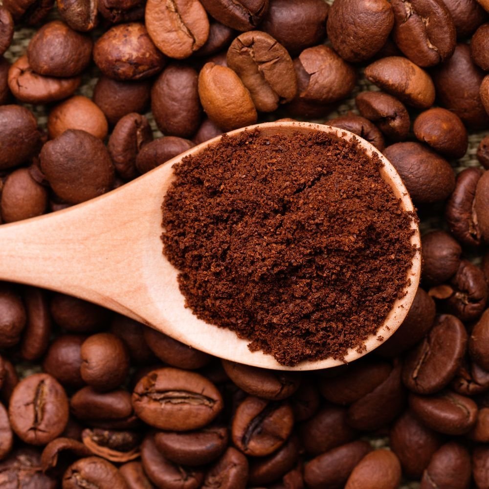 Various coffee brewing tools and ground coffee arranged neatly on a wooden kitchen tray.