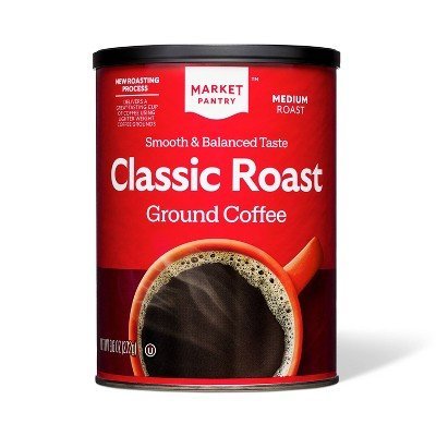 Whole roasted coffee beans and ground coffee beans displayed on a dark slate surface.