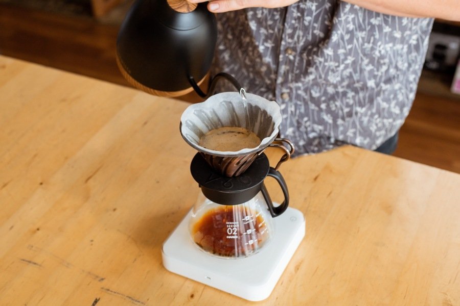 A steaming cup of coffee on a wooden desk during an educational session.