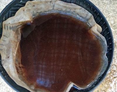 A person inspecting a coffee filter basket for damage in a kitchen.
