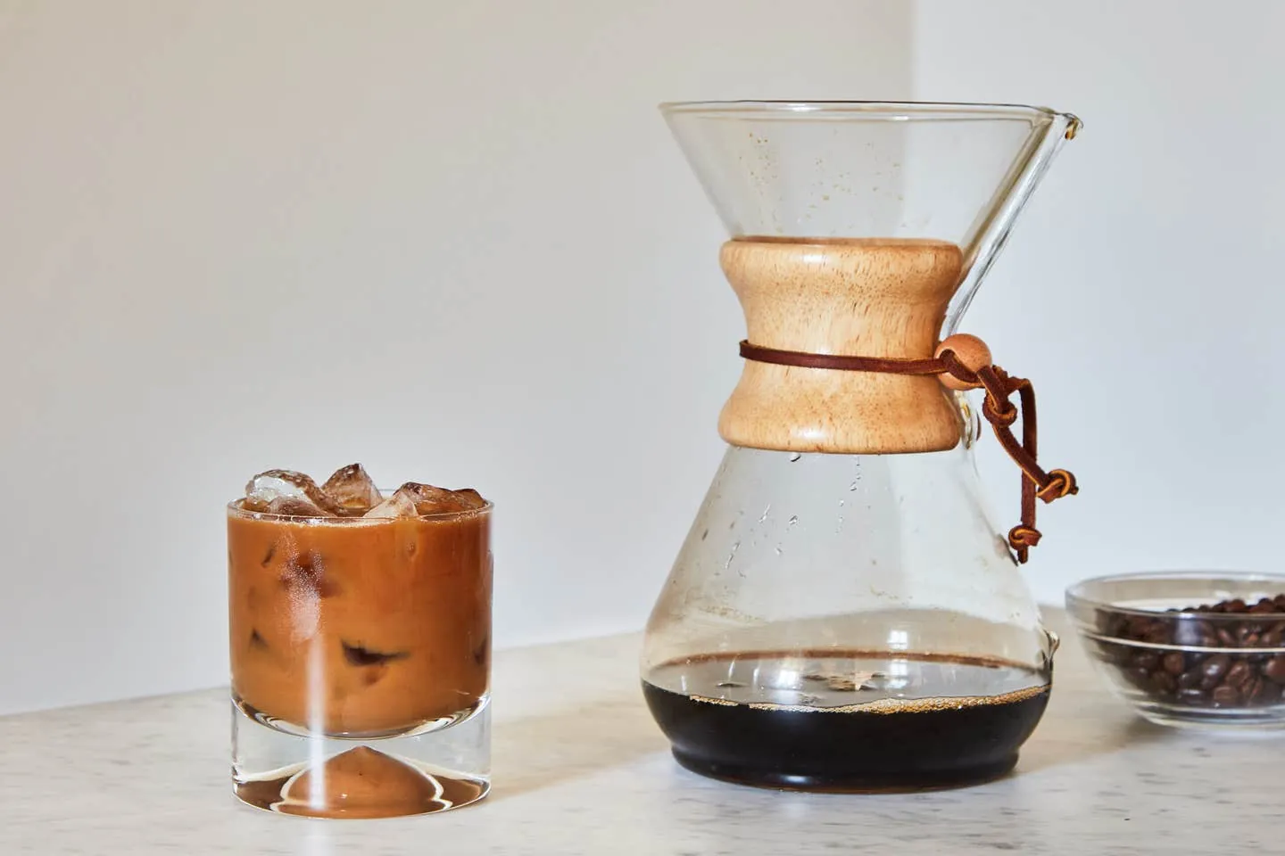 Coarse coffee grounds being poured into a glass jar on a scale
