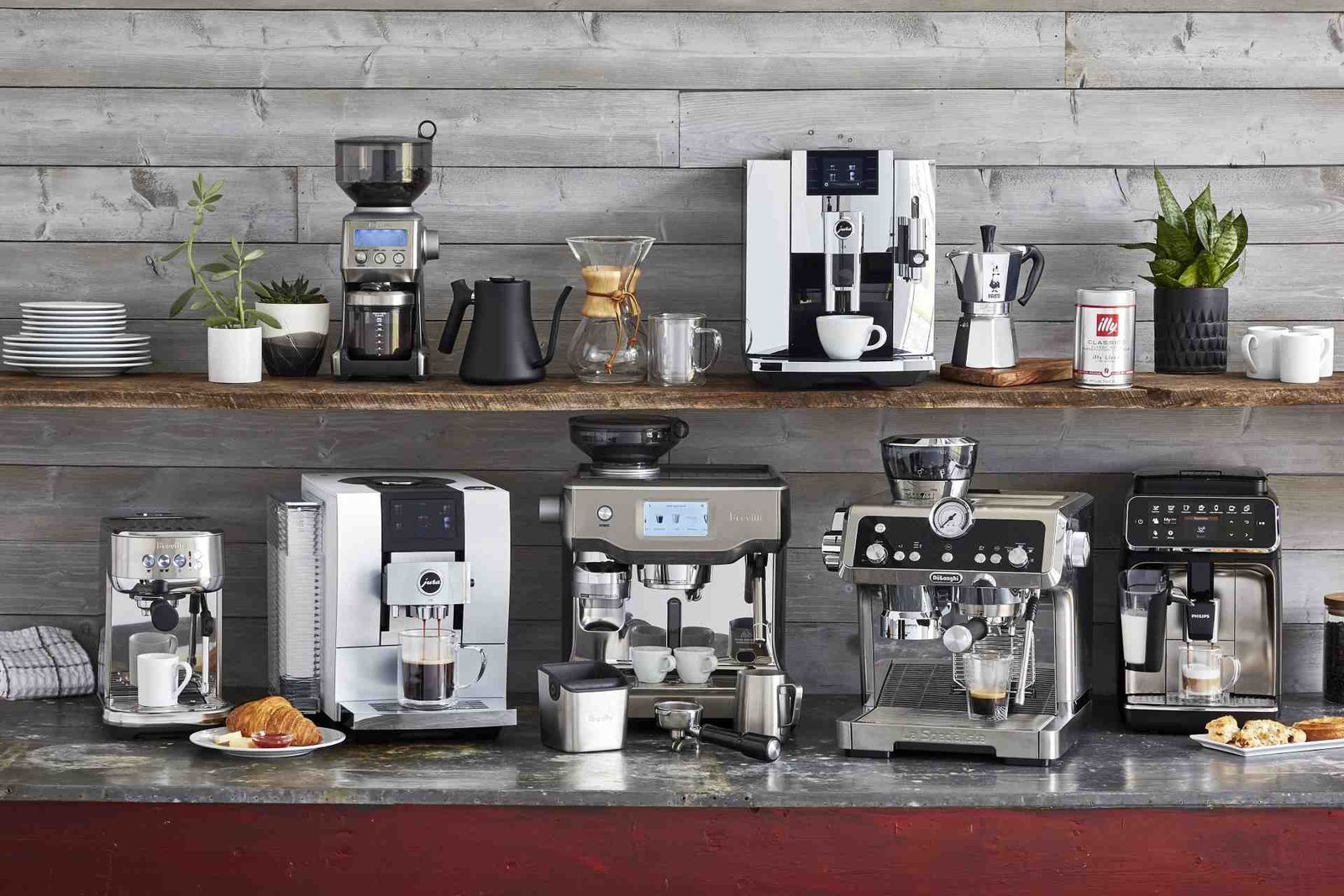 Stainless steel espresso machine on a marble counter with roasted coffee beans.