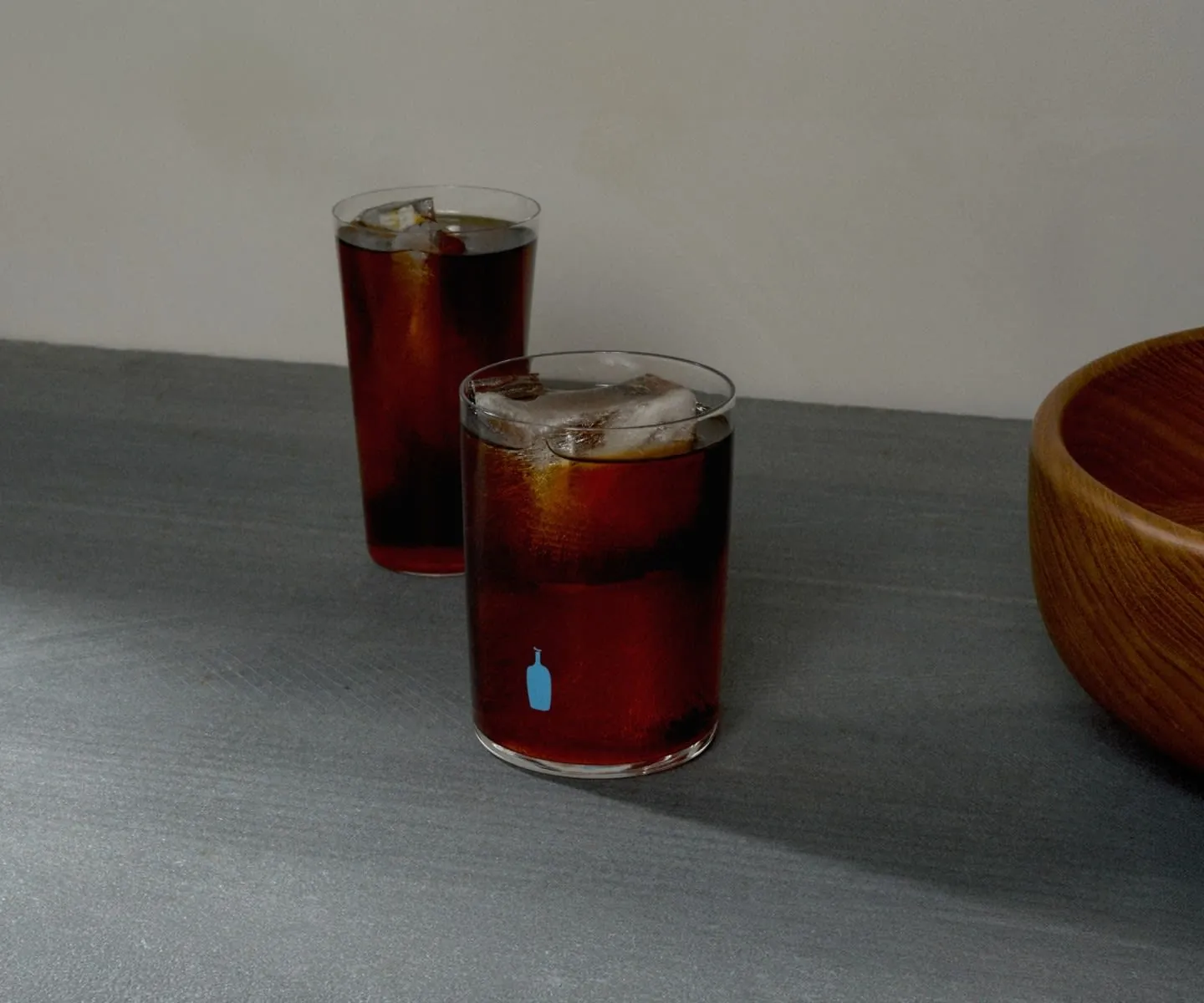Two jars of cold brew coffee showing different steep times on a table.